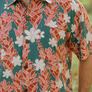 man wearing an aloha button up shirt with red ginger and tiare print