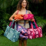 woman carrying canopy green colored neoprene tote bag with thick straps and detachable pouch with naupaka print