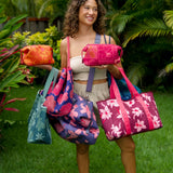 woman carrying large dark navy blue everyday tote bag with rope straps, detachable mini pouch, and bright pink hibiscus print