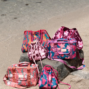 brown neoprene drawstring crossbody purse with pink hibiscus pattern