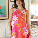 woman with brown hair wearing pink high neck scoop back mini dress with retro flower print
