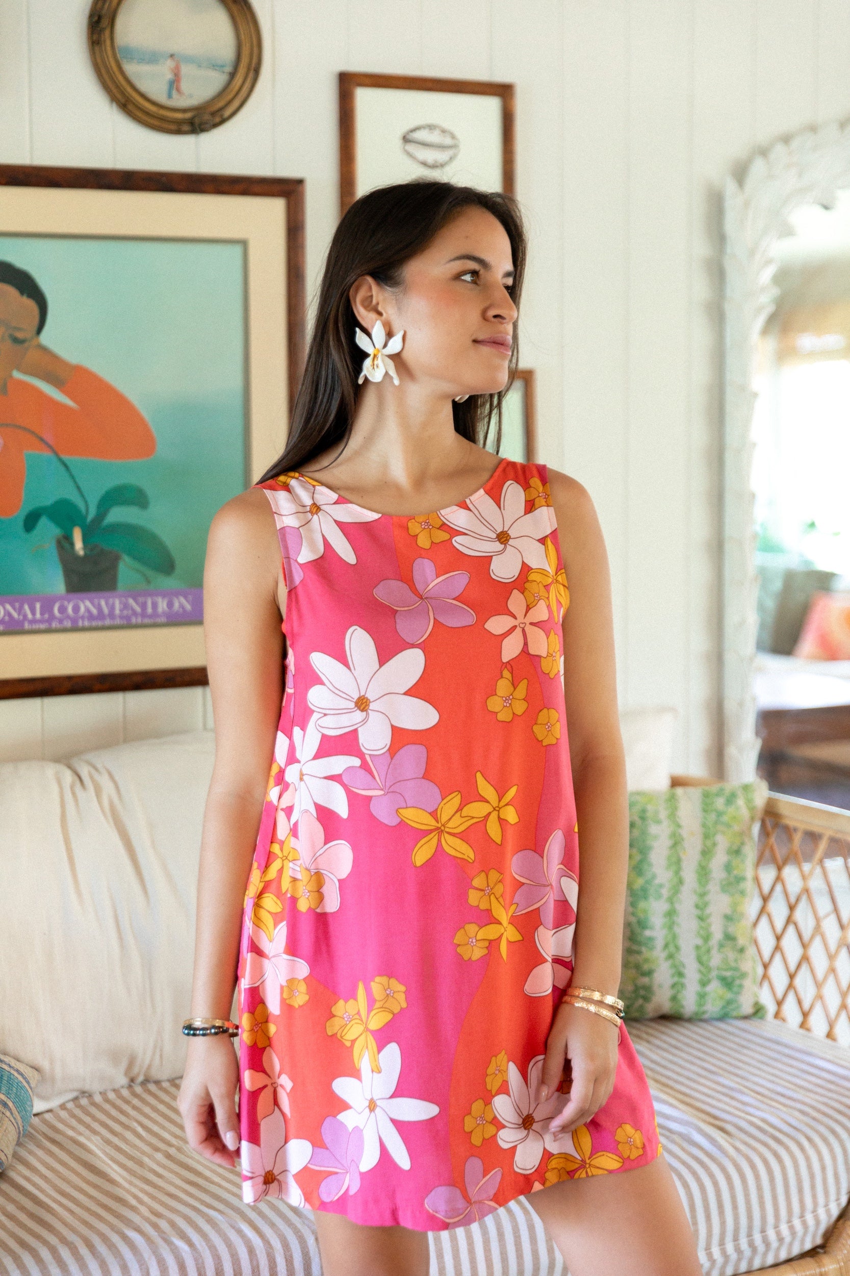 woman with brown hair wearing pink high neck scoop back mini dress with retro flower print