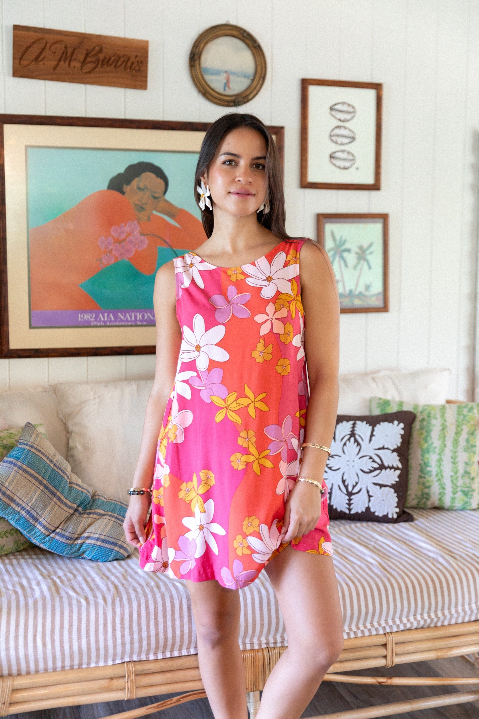  woman with brown hair wearing pink high neck scoop back mini dress with retro flower print