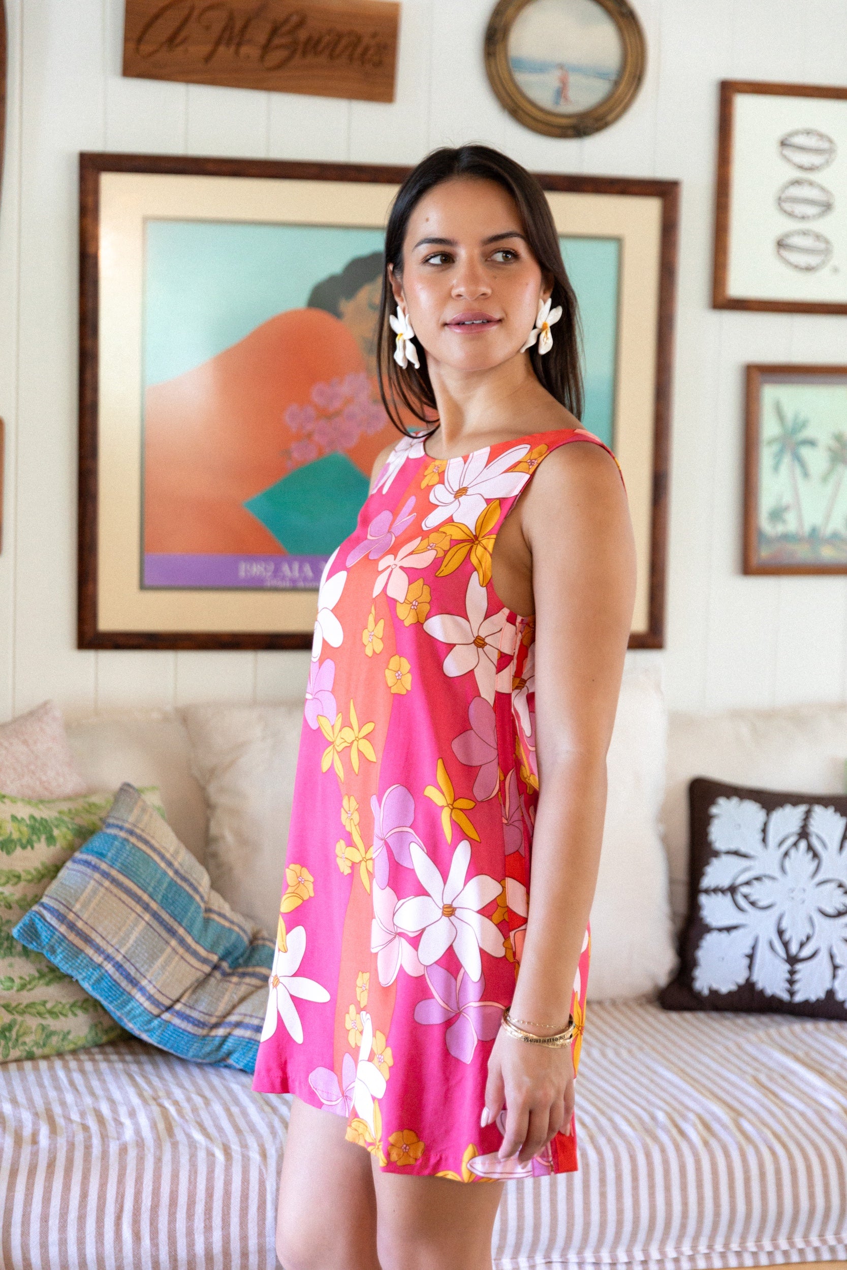 woman with brown hair wearing a pink high neck scoop back mini dress with retro flower print
