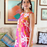 woman with brown hair wearing pink high neck scoop back mini dress with retro flower print