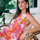 woman with brown hair wearing pink high neck scoop back mini dress with retro flower print