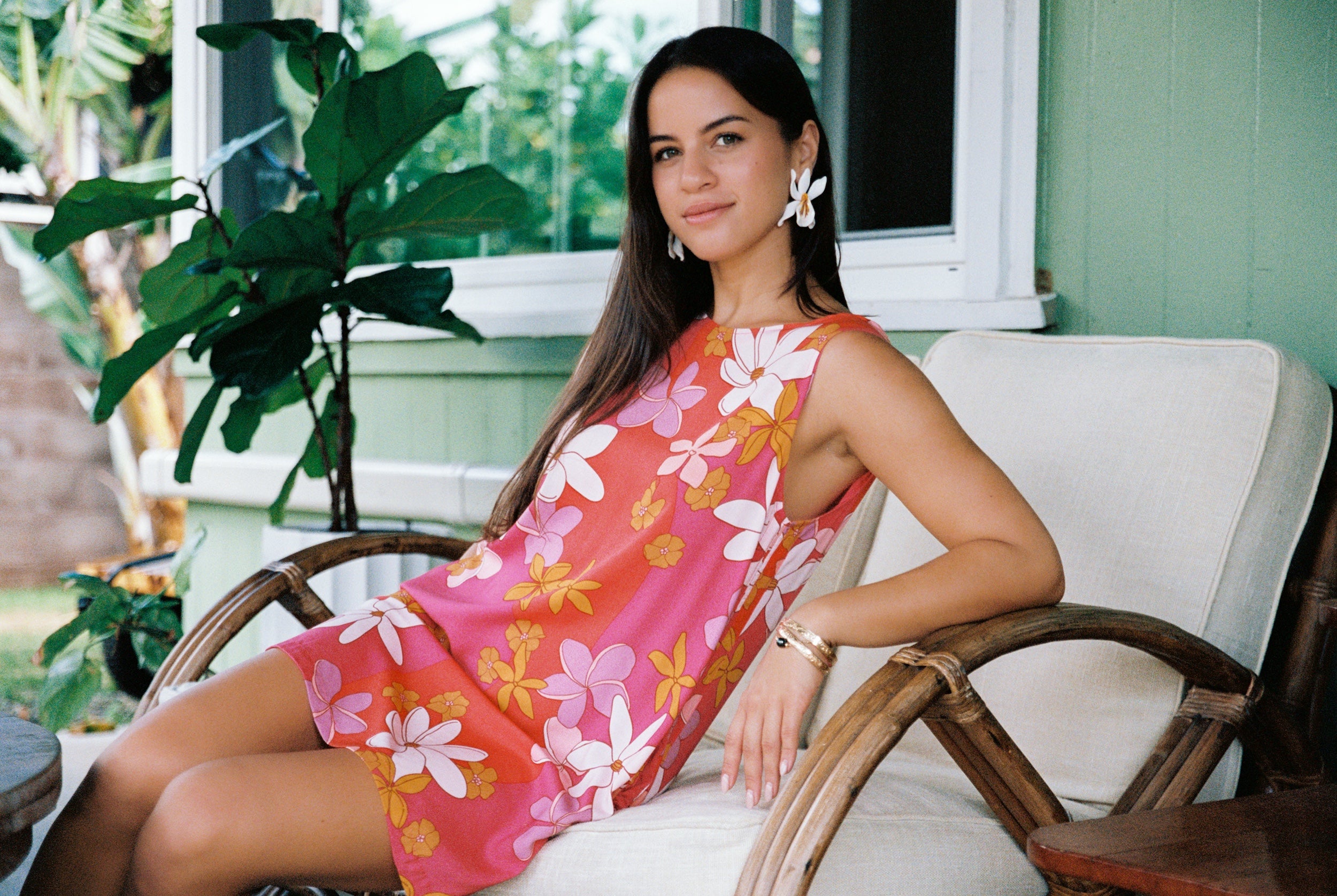 woman with brown hair wearing pink high neck scoop back mini dress with retro flower print