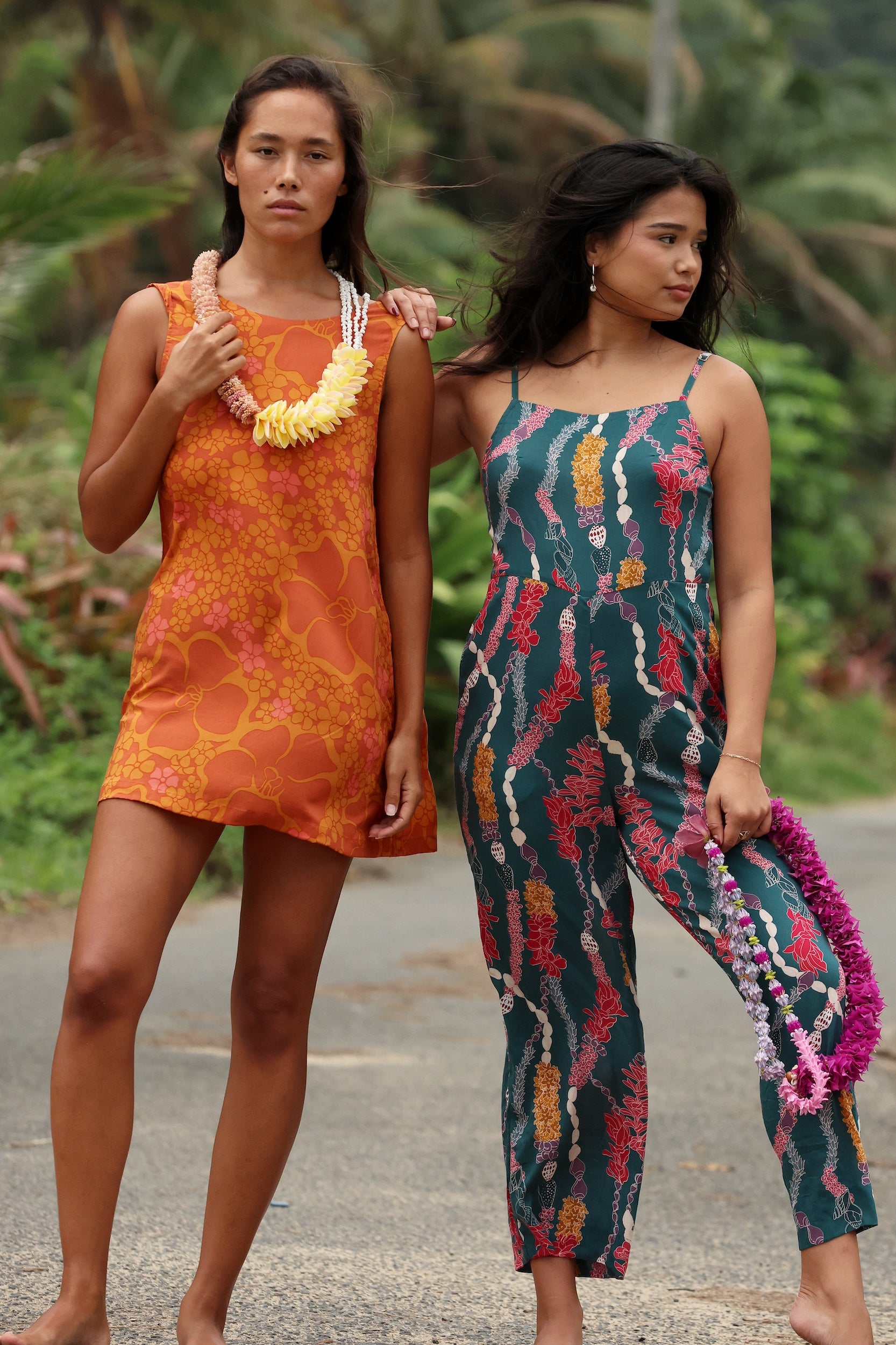 woman with brown hair wearing a retro orange mini scoop back dress with puakenikeni print