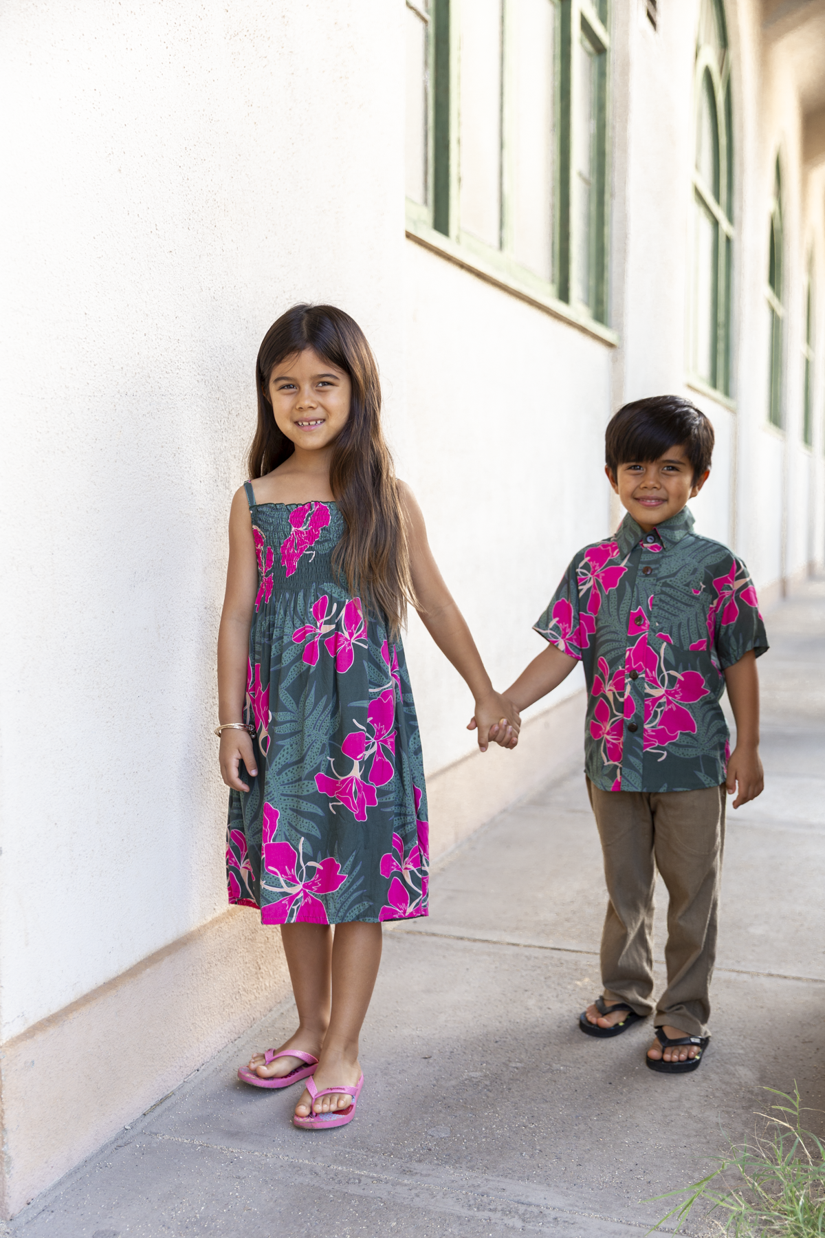 little girl with brown hair wearing a smocked spaghetti strap dress with fern and ginger print