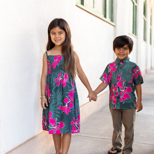 little girl with brown hair wearing a smocked spaghetti strap dress with fern and ginger print