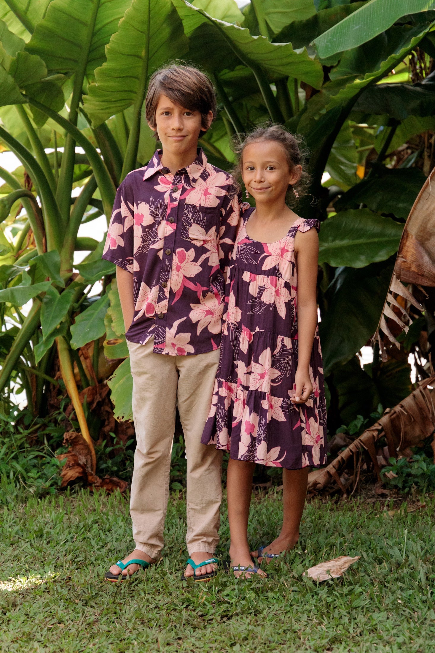 little girl wearing dark purple dress with flutter sleeve and orchid print