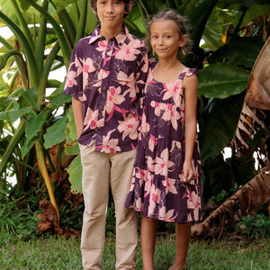 little girl wearing dark purple dress with flutter sleeve and orchid print