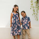 little girl wearing a tiered maxi dress in navy and pink hibiscus print.