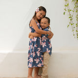 little girl wearing a tiered maxi dress in navy and pink hibiscus print.