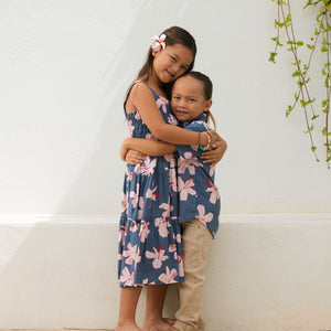 little girl wearing a tiered maxi dress in navy and pink hibiscus print.
