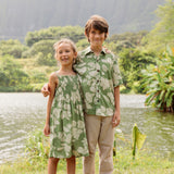 little girl wearing green smocked dress with native Hawaiian plants