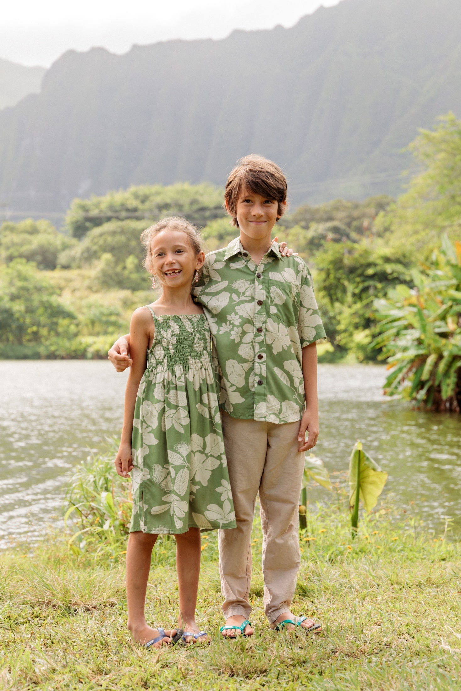little girl wearing green smocked dress with native Hawaiian plants