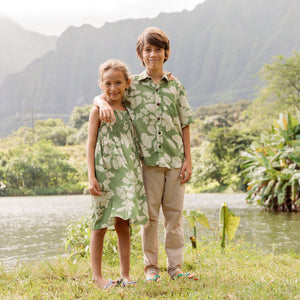little girl wearing green smocked dress with native Hawaiian plants