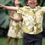 little boy wearing mini aloha button up shirt in green print and naupaka pattern