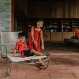 little girl wearing jumpsuit with retro pink pua pattern