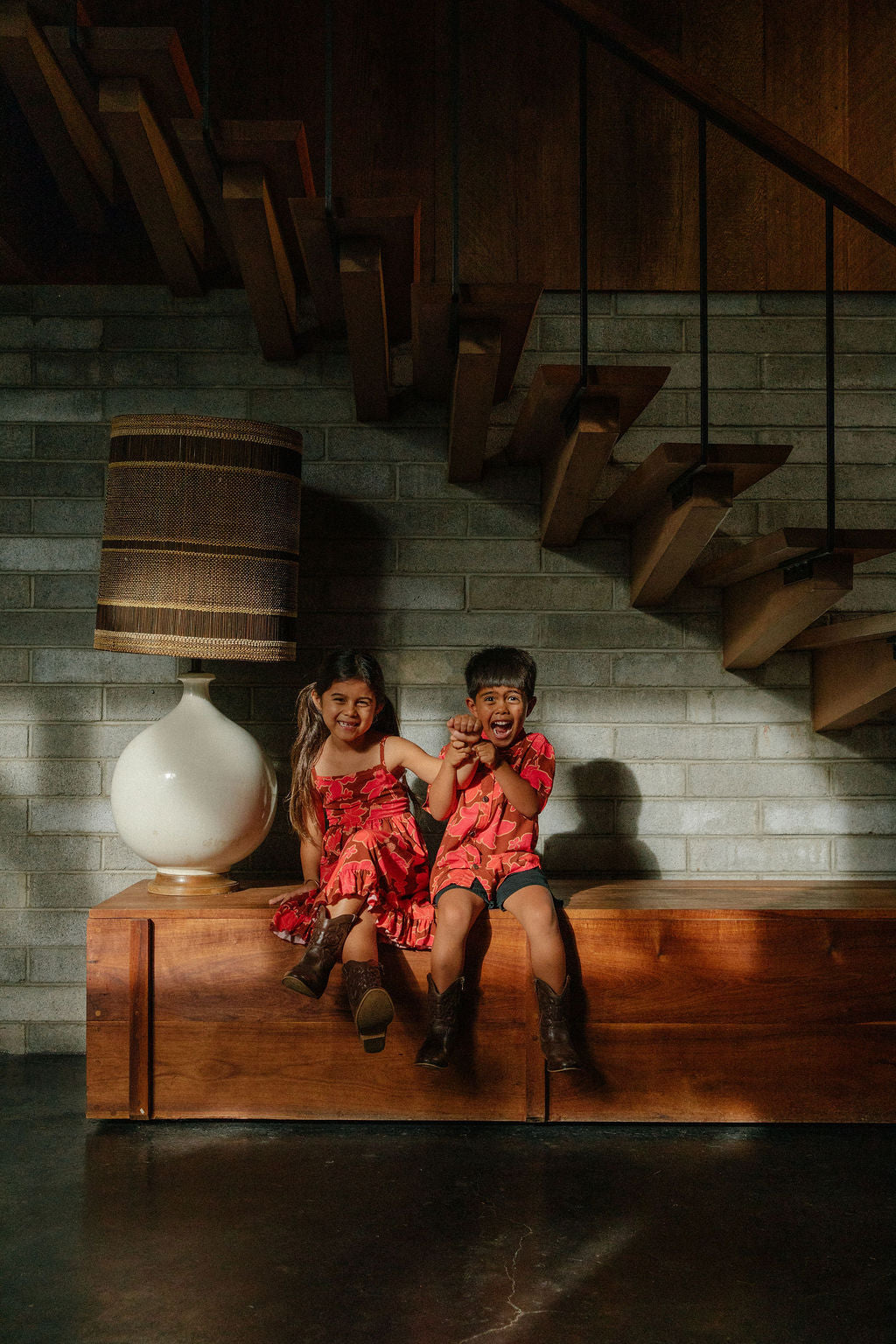 litte boy wearing aloha button up shirt with vibrant pink pua pattern
