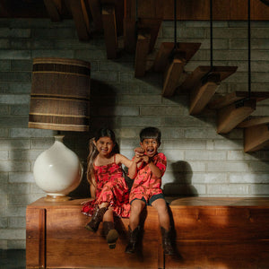 litte boy wearing aloha button up shirt with vibrant pink pua pattern