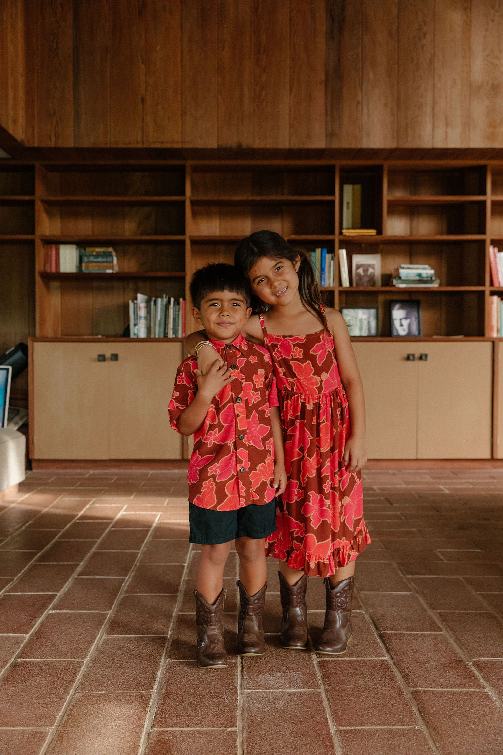 little girl wearing tie back dress with retro pink pua pattern