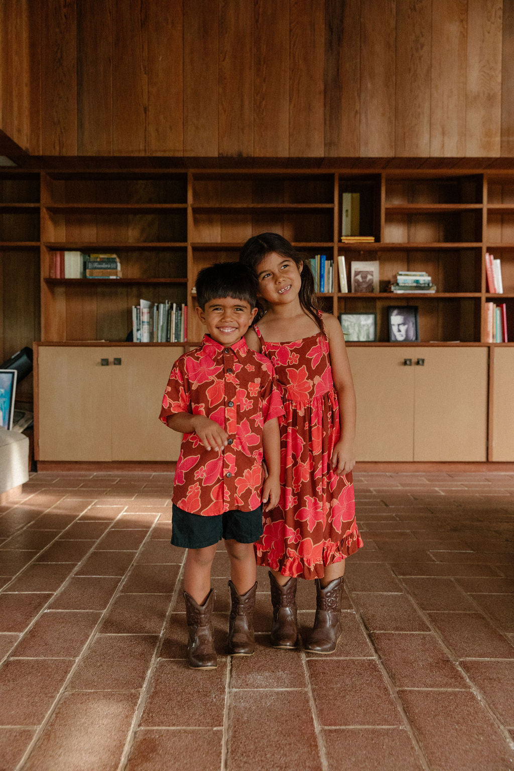 litte boy wearing aloha button up shirt with vibrant pink pua pattern