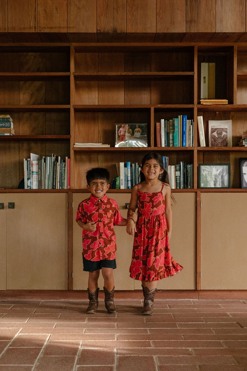 little girl wearing tie back dress with retro pink pua pattern