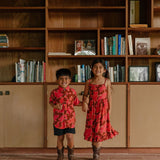 little girl wearing tie back dress with retro pink pua pattern