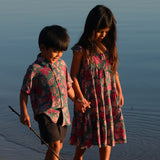 little girl wearing a teal dress with flutter sleeves with shell and pua print