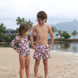 little girl wearing long sleeve one piece bikini in blush and brown hibiscus print.