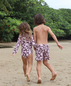 little girl wearing long sleeve one piece bikini in blush and brown hibiscus print.