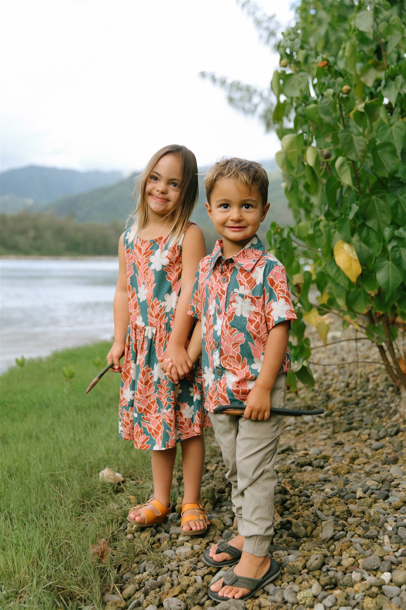 little boy wearing an aloha button up shirt with red ginger and tiare print