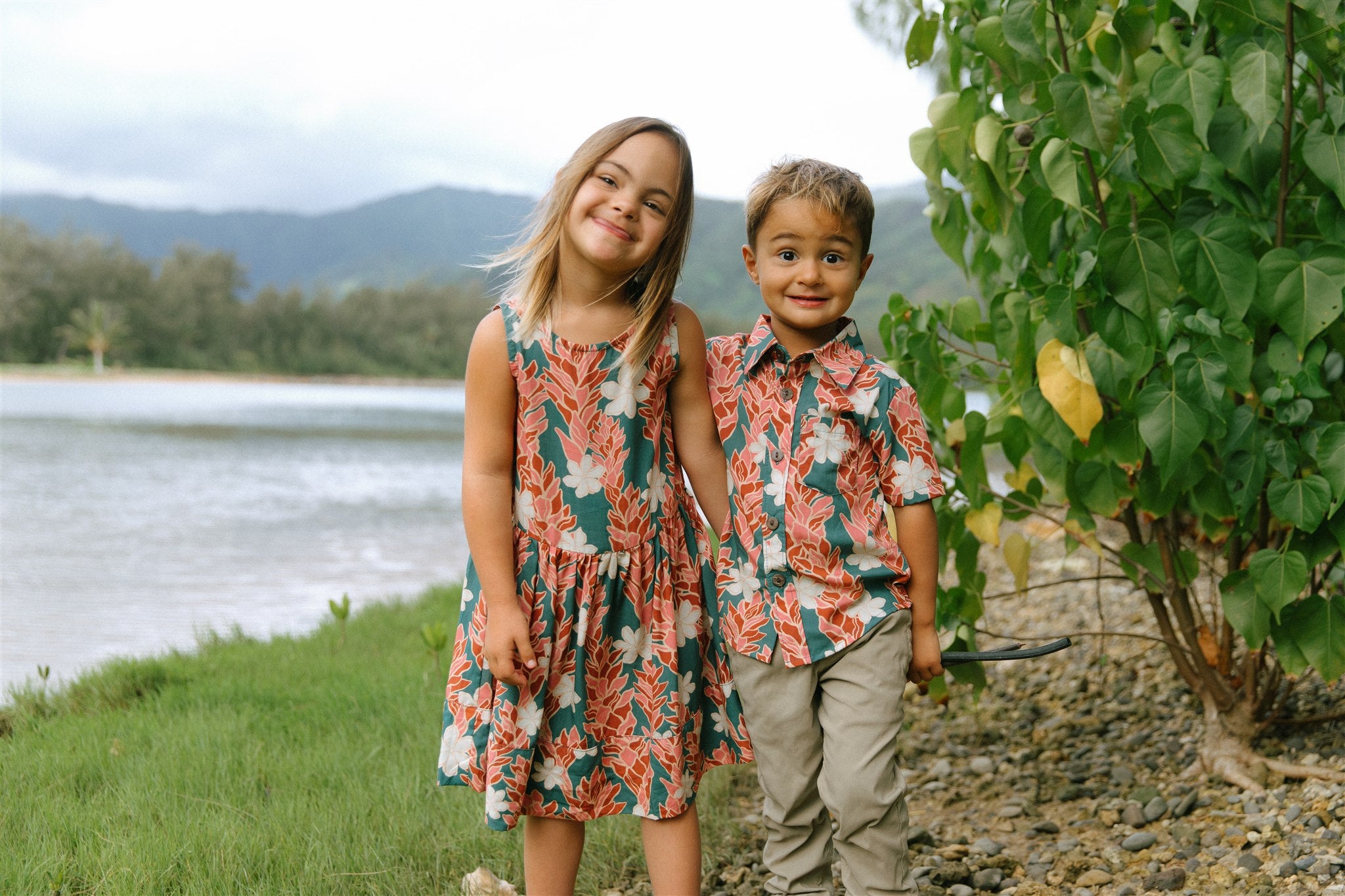 little boy wearing an aloha button up shirt with red ginger and tiare print