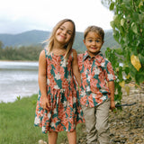 little boy wearing an aloha button up shirt with red ginger and tiare print