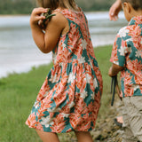 little girl wearing a knee length dress with red ginger and tiare print