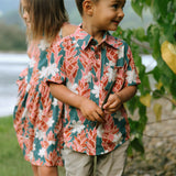 little boy wearing an aloha button up shirt with red ginger and tiare print