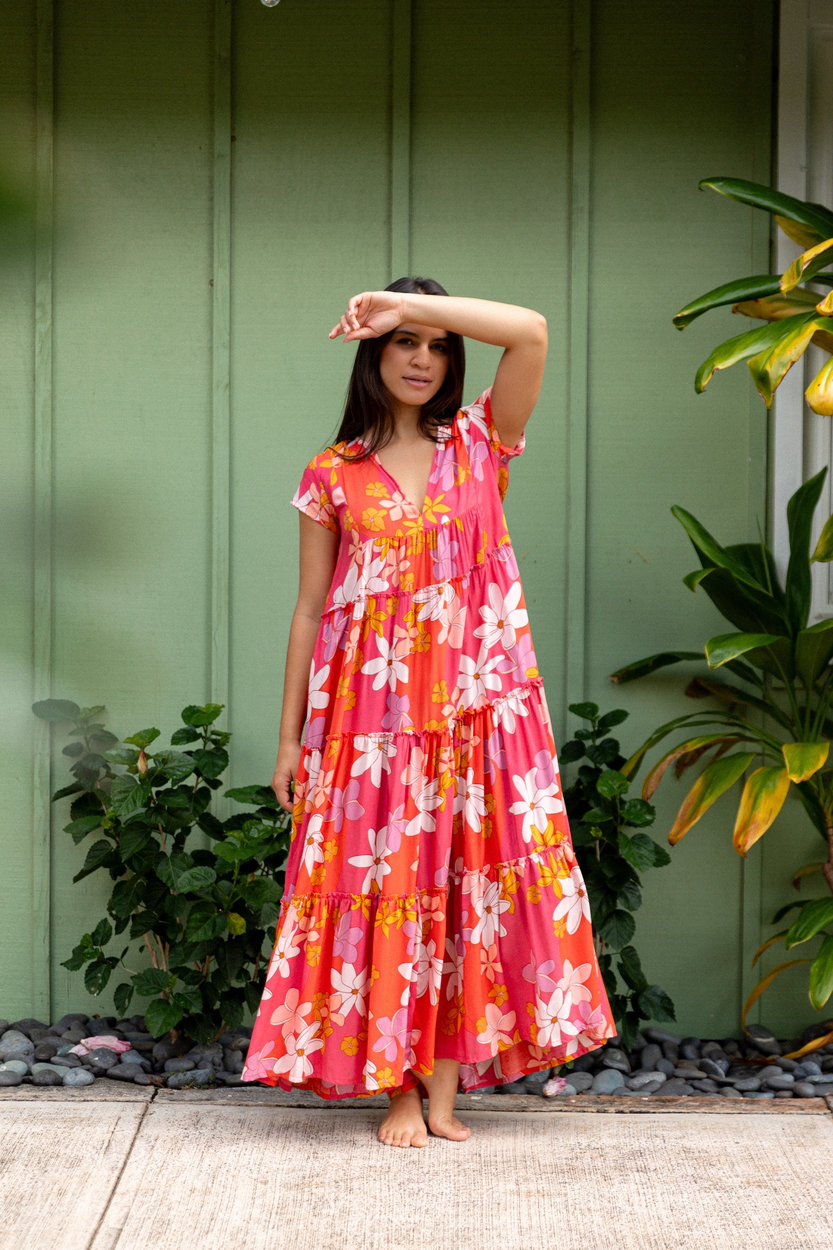woman with brown hair wearing a pink short sleeve tiered maxi dress with retro flower print