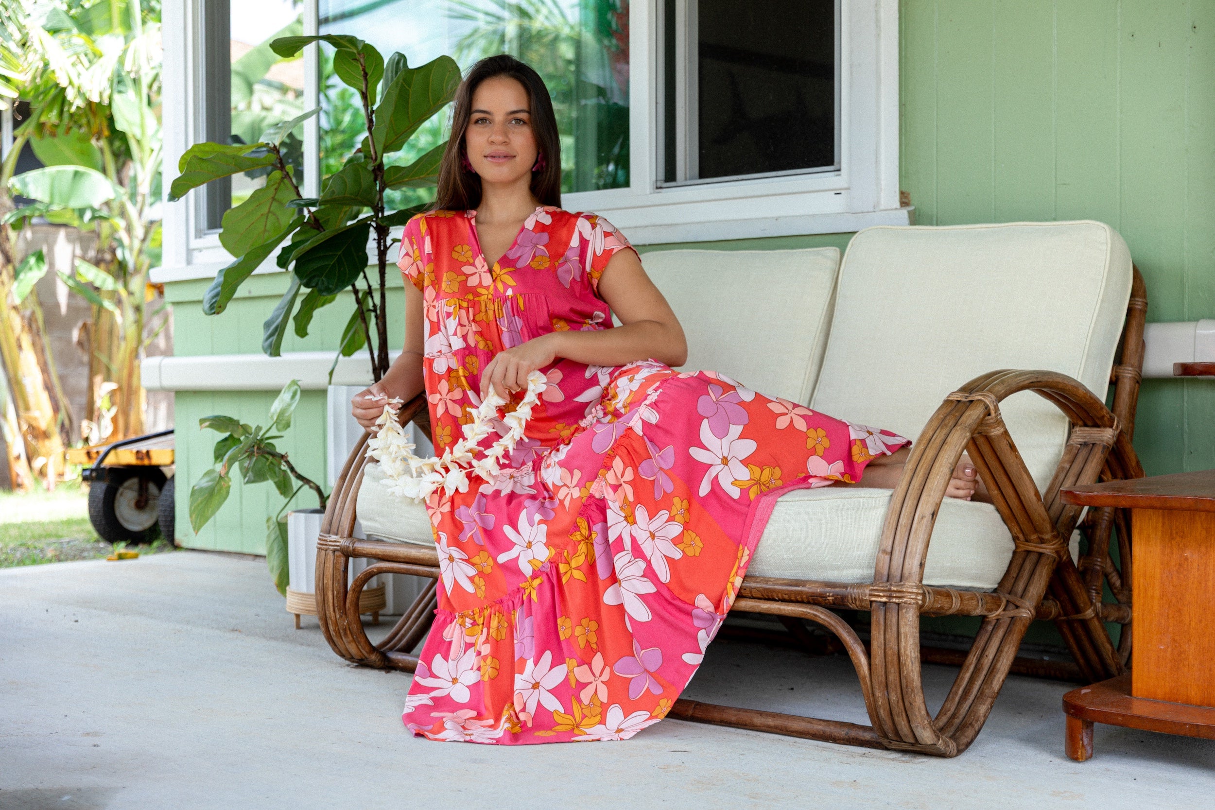 woman with brown hair wearing a pink short sleeve tiered maxi dress with retro flower print