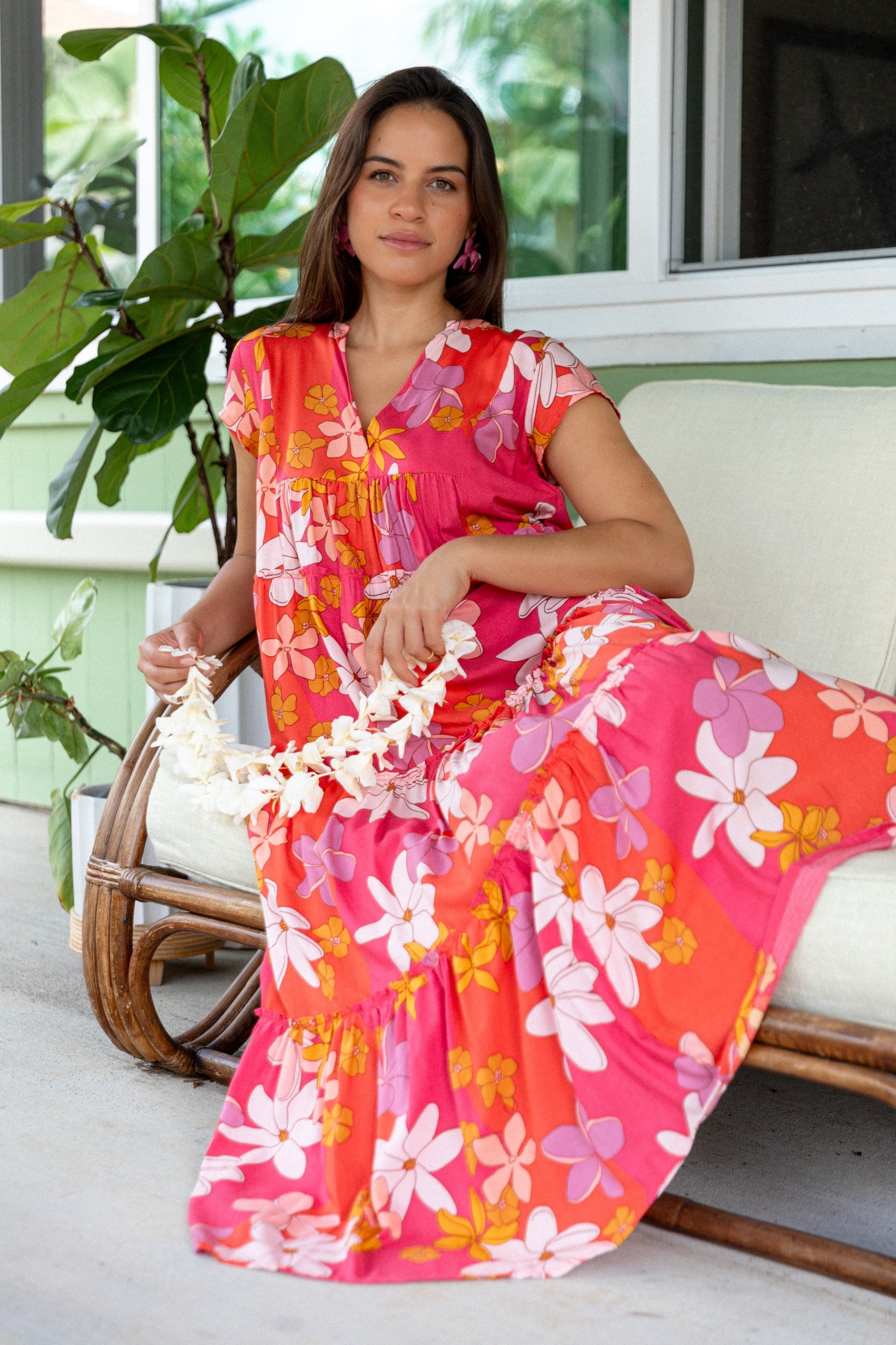 woman with brown hair wearing a pink short sleeve tiered maxi dress with retro flower print