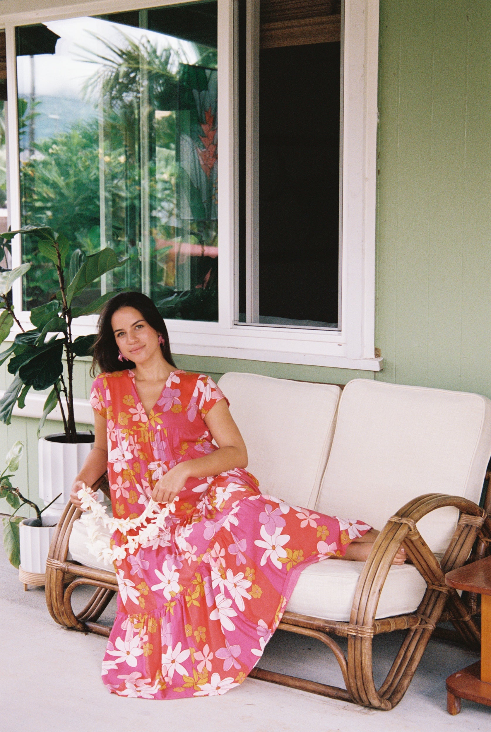 woman with brown hair wearing a pink short sleeve tiered maxi dress with retro flower print