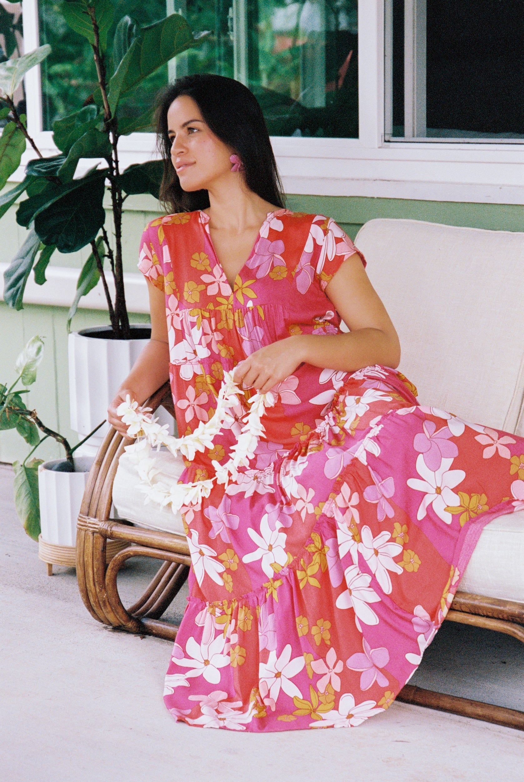 woman with brown hair wearing a pink short sleeve tiered maxi dress with retro flower print