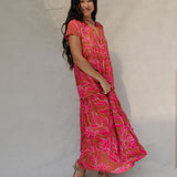 woman with brown hair wearing a sienna colored maxi v neck dress with awapuhi pattern