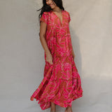 woman with brown hair wearing a sienna colored maxi v neck dress with awapuhi pattern