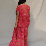 woman with brown hair wearing a sienna colored maxi v neck dress with awapuhi pattern