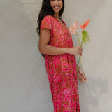 woman with brown hair wearing a sienna colored maxi v neck dress with awapuhi pattern