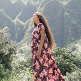 woman wearing dark purple maxi dress with orchid print