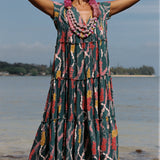 woman with brown hair wearing long tiered maxi dress in dark teal with shell lei print