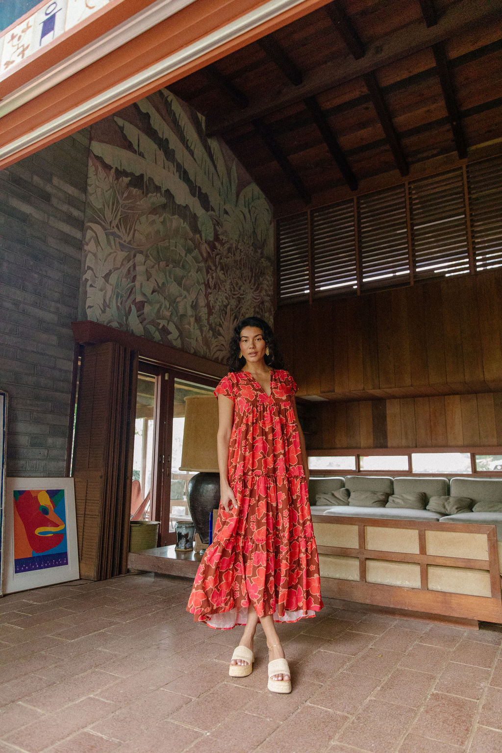 woman with brown hair wearing a flowy maxi tiered dress with retro pink pua print